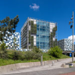Außenansicht des Gebäudekomplexes des Internationalen Strafgerichtshofs in Den Haag bei blauem Himmel.