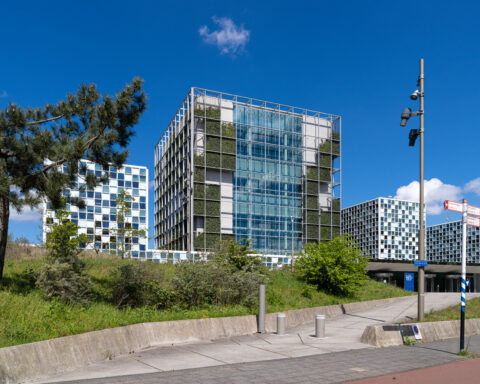 Außenansicht des Gebäudekomplexes des Internationalen Strafgerichtshofs in Den Haag bei blauem Himmel.
