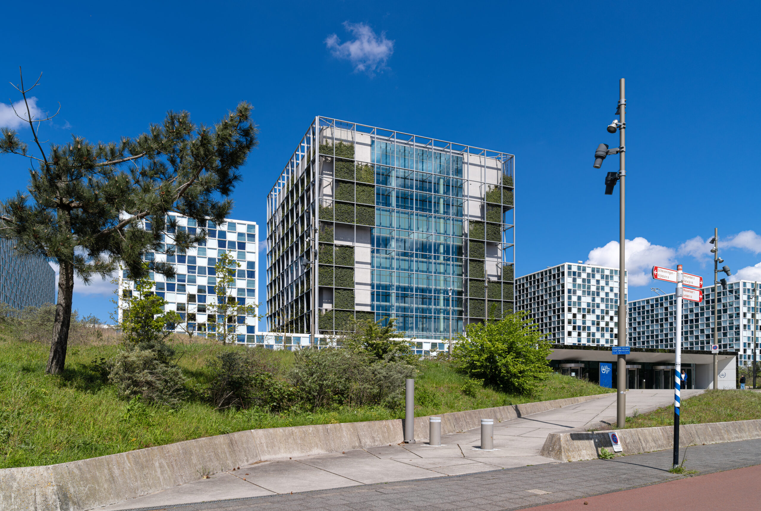 Außenansicht des Gebäudekomplexes des Internationalen Strafgerichtshofs in Den Haag bei blauem Himmel.