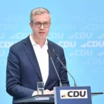 Stefan Evers spricht an einem CDU-Pult vor blauem Hintergrund.