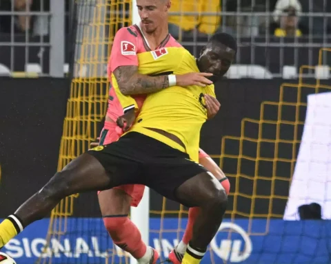 Zwei Fußballspieler im Zweikampf vor dem Tor, einer im gelben Trikot von Borussia Dortmund.