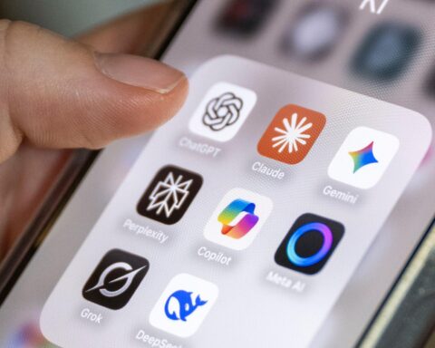 Hand hält ein Smartphone mit mehreren KI-App-Symbolen auf dem Bildschirm.