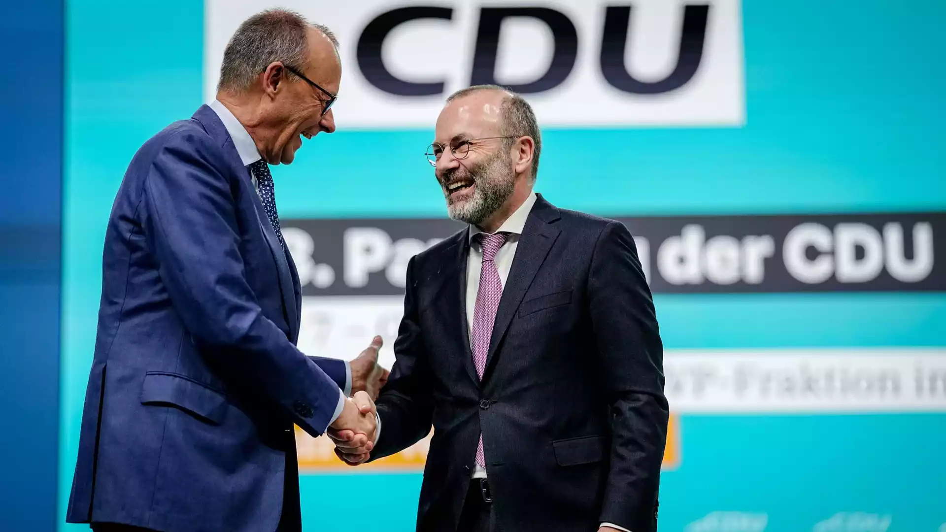 Union streitet vor CDU-Präsidiumsklausur über AfD-Kurs 1 Zwei CDU-Politiker schütteln sich auf einer Bühne vor einem CDU-Hintergrund die Hand.