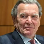 Gerhard Schröder in einem dunklen Anzug bei einer Veranstaltung.