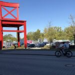 Außenansicht eines XXXLutz-Möbelhauses mit großem roten Wahrzeichen und Parkplatz.