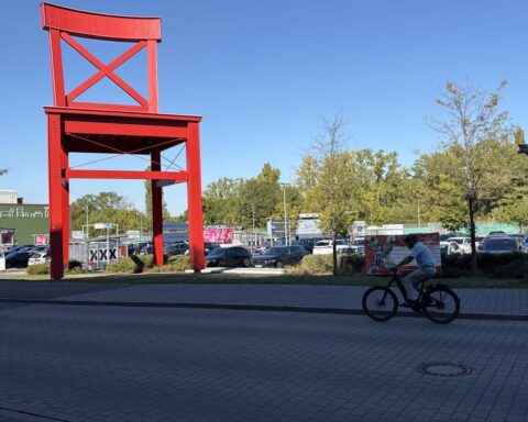 Außenansicht eines XXXLutz-Möbelhauses mit großem roten Wahrzeichen und Parkplatz.