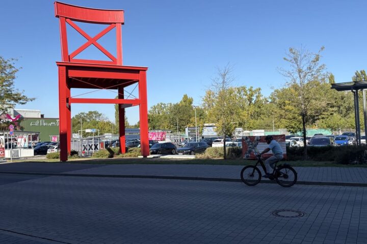 Außenansicht eines XXXLutz-Möbelhauses mit großem roten Wahrzeichen und Parkplatz.