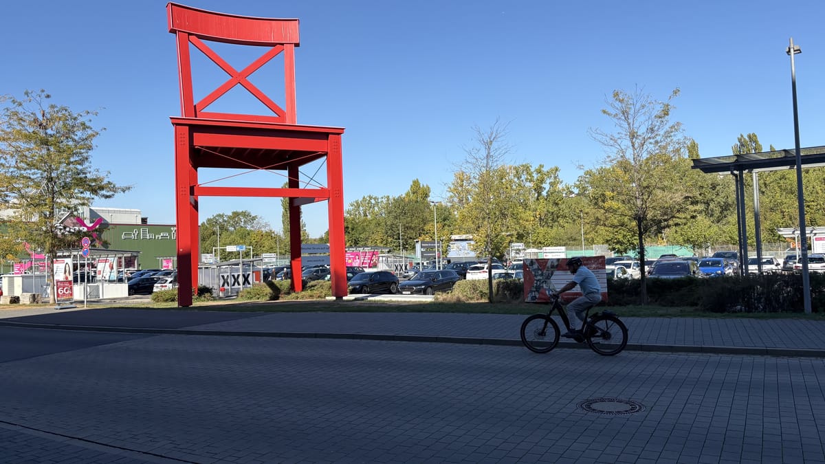 Außenansicht eines XXXLutz-Möbelhauses mit großem roten Wahrzeichen und Parkplatz.