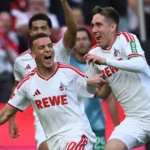 Spieler des 1. FC Köln jubeln nach einem Tor vor den Fans im Stadion.