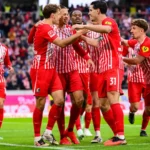 SC Freiburg-Spieler feiern auf dem Rasen nach einer Szene im Bundesliga-Spiel gegen Schalke.