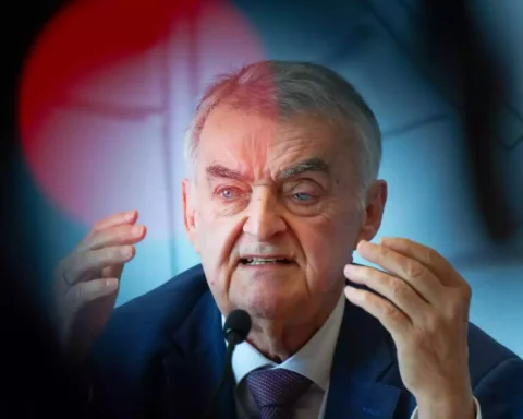 Herbert Reul spricht an einem Mikrofon und gestikuliert mit beiden Händen.