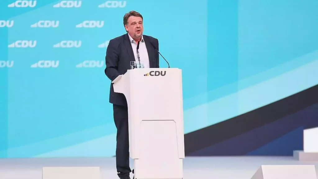 Mann spricht an einem Podium vor einem CDU-Hintergrund.