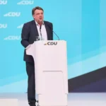 Mann spricht an einem Podium vor einem CDU-Hintergrund.