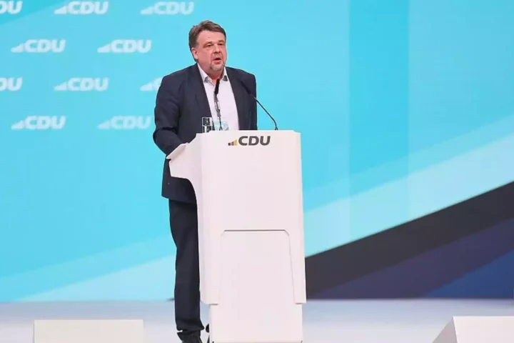 Mann spricht an einem Podium vor einem CDU-Hintergrund.
