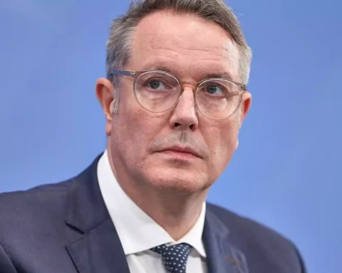 Alexander Schweitzer im Anzug vor blauem Hintergrund.
