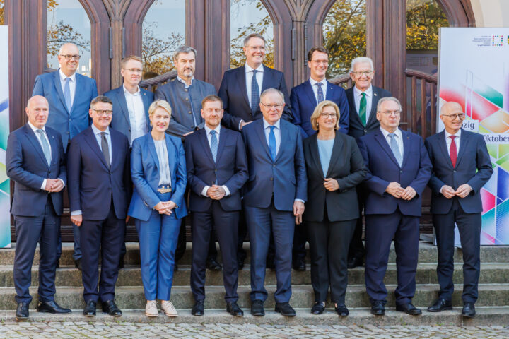 Mehrere Politikerinnen und Politiker posieren vor einem Gebäude für ein Gruppenfoto.