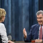 Markus Söder sitzt in einer TV-Sendung im Studio und spricht mit einer Moderatorin.