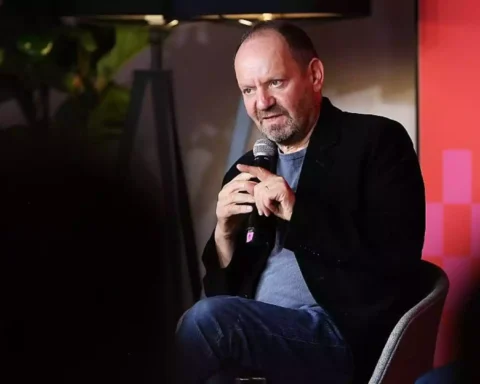 Philippe Sands sitzt mit einem Mikrofon auf einer Bühne bei einer Veranstaltung.