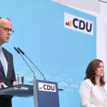 Friedrich Merz spricht an einem CDU-Pult bei einer Pressekonferenz, neben ihm steht eine weitere Person.