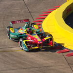 Formel-E-Rennwagen mit Schaeffler-Branding fährt auf einer Rennstrecke an einer gelben Barriere vorbei.