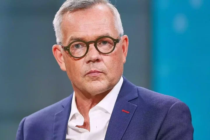 Michael Roth in einem Studio-Porträt mit Brille und blauem Sakko.