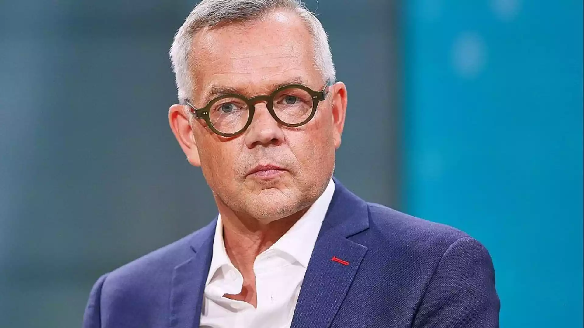 Michael Roth in einem Studio-Porträt mit Brille und blauem Sakko.