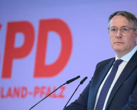 Alexander Schweitzer steht vor einem SPD-Hintergrund an einem Rednerpult.