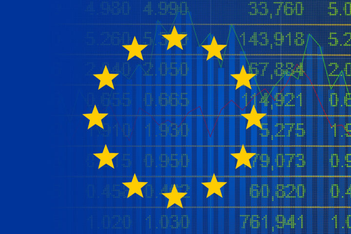 Europäische Flagge vor einem Börsenkursdiagramm mit Kurszahlen im Hintergrund.