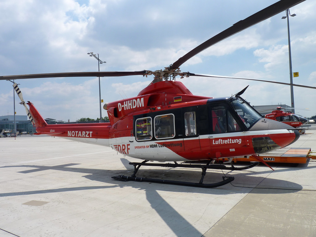Roter Rettungshubschrauber steht auf dem Vorfeld eines Flughafens.