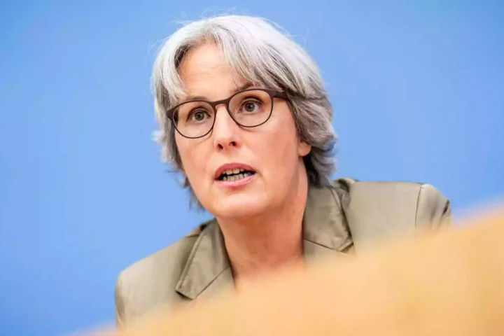 Kerstin Claus spricht vor blauem Hintergrund bei einer Pressekonferenz.
