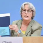 Kerstin Claus hält bei einer Pressekonferenz ihren Bericht zum Kinderschutz in die Kamera.