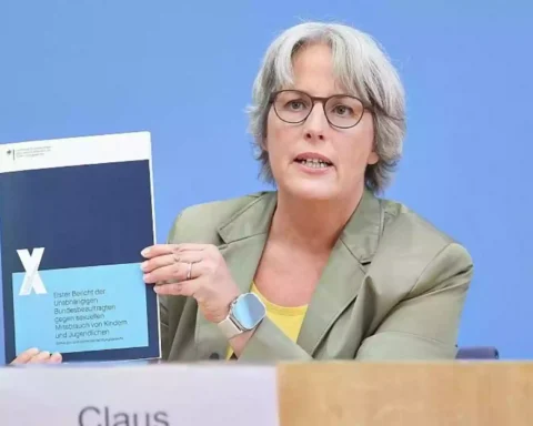 Kerstin Claus hält bei einer Pressekonferenz ihren Bericht zum Kinderschutz in die Kamera.