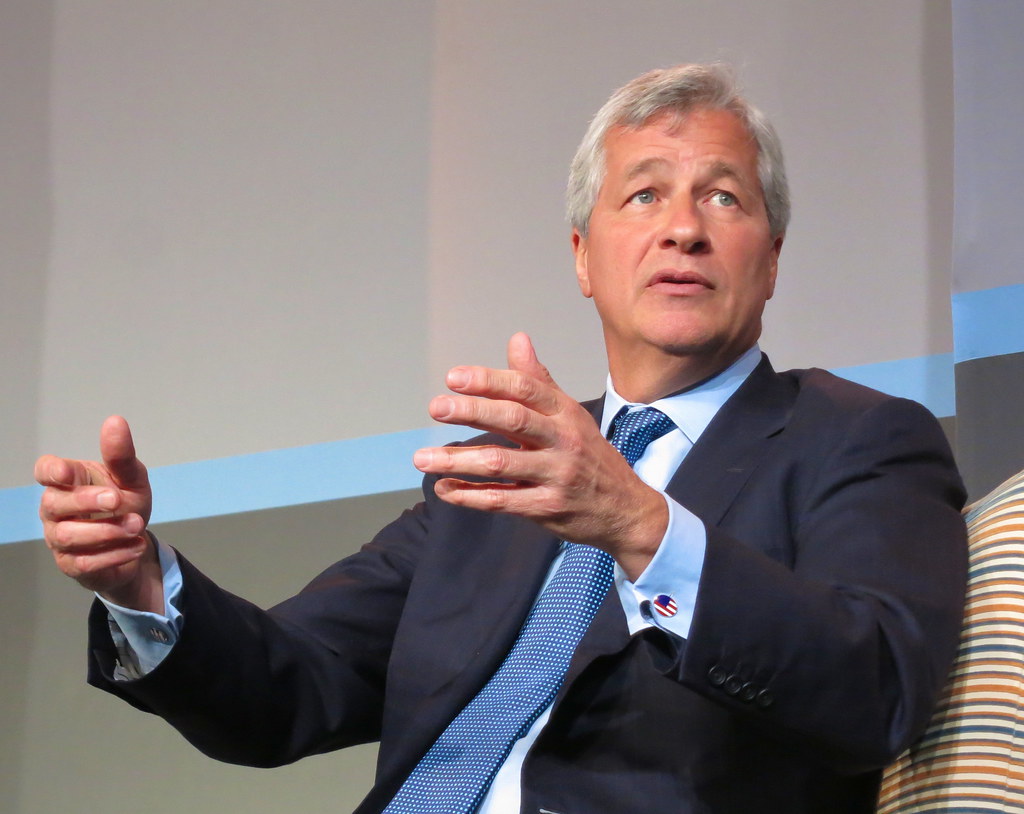 JPMorgan steigert Quartalsgewinn, Aktie fällt vorbörslich 1 Jamie Dimon sitzt im Anzug und spricht bei einer Veranstaltung.