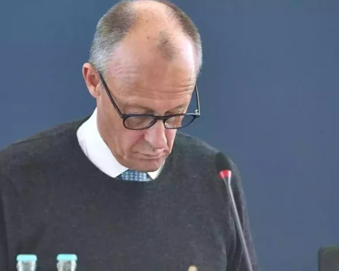 Friedrich Merz blickt bei einer politischen Sitzung nach unten, vor ihm steht ein Mikrofon.