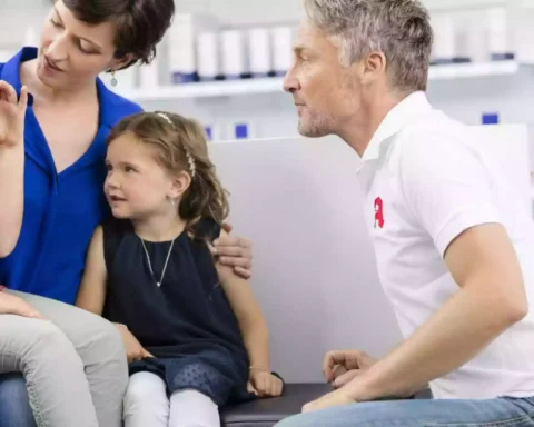 Ein Apotheker berät eine Frau mit zwei Kindern in einer Apotheke.