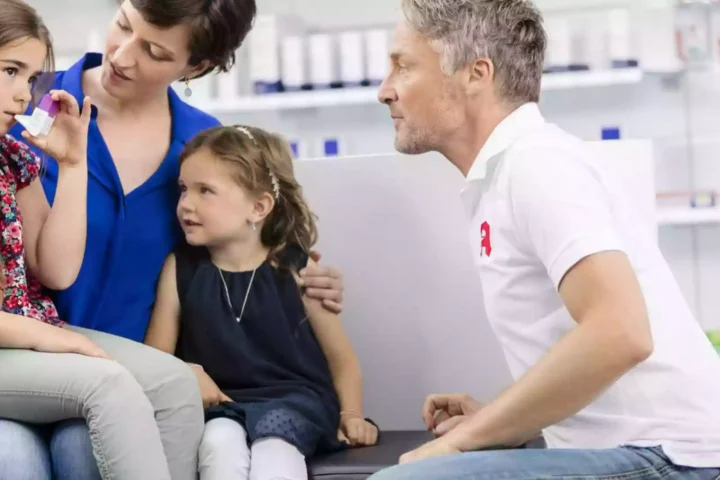 Ein Apotheker berät eine Frau mit zwei Kindern in einer Apotheke.