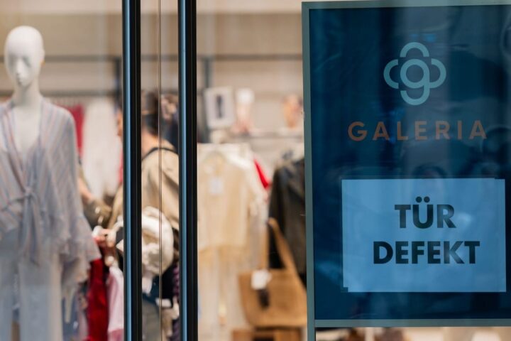 Galeria-Schaufenster mit Modepuppen und Schild „Tür defekt“.