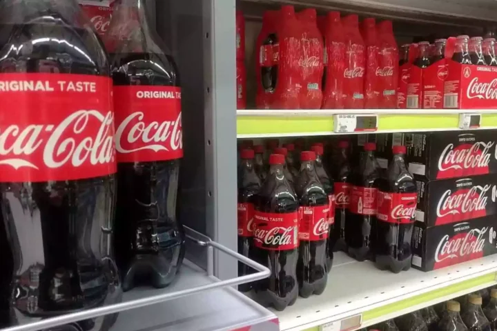 Coca-Cola-Flaschen und Mehrwegpackungen in einem Supermarktregal.