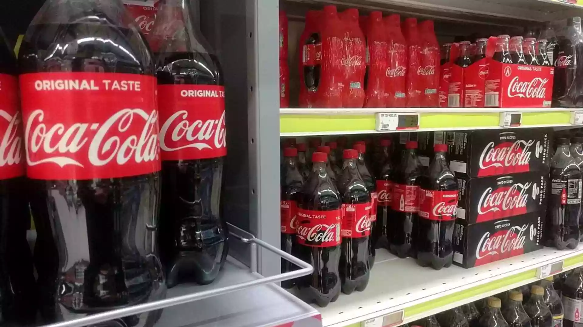 Coca-Cola-Flaschen und Mehrwegpackungen in einem Supermarktregal.
