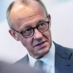 Friedrich Merz spricht in einem Gespräch und schaut zur Seite.