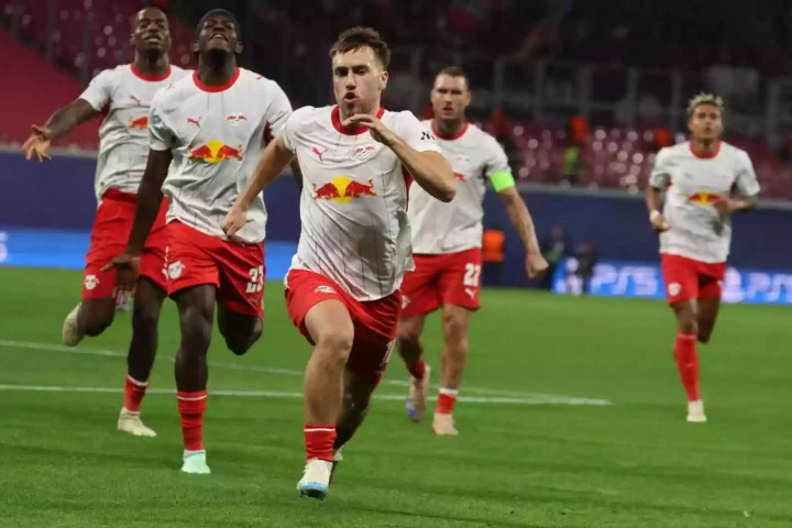 RB-Leipzig-Spieler jubeln und sprinten auf dem Rasen im Stadion.