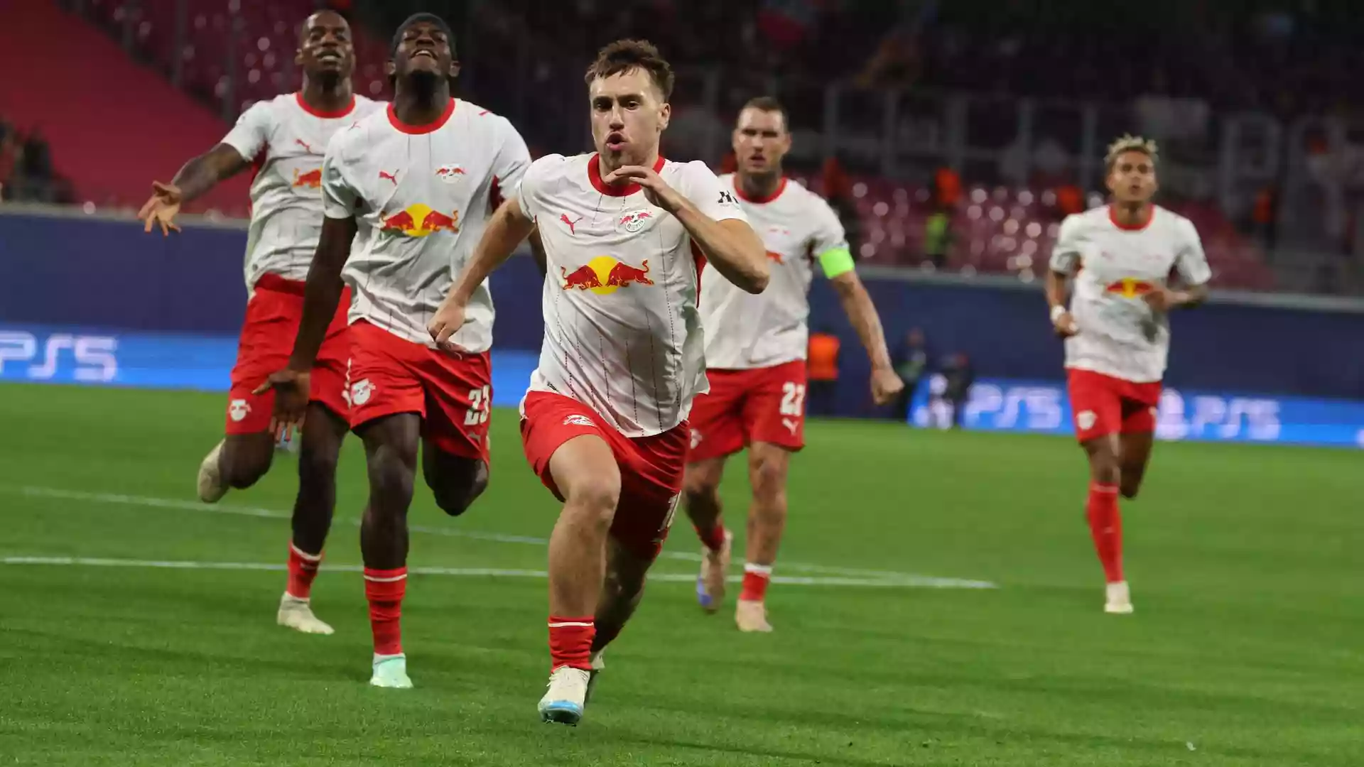 RB-Leipzig-Spieler jubeln und sprinten auf dem Rasen im Stadion.