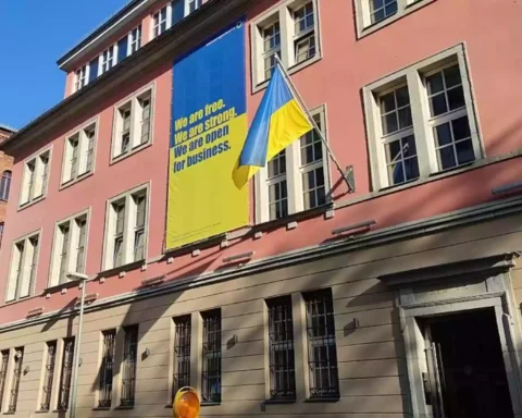 Gebäude mit ukrainischer Flagge und großem Unterstützungsbanner an der Fassade.