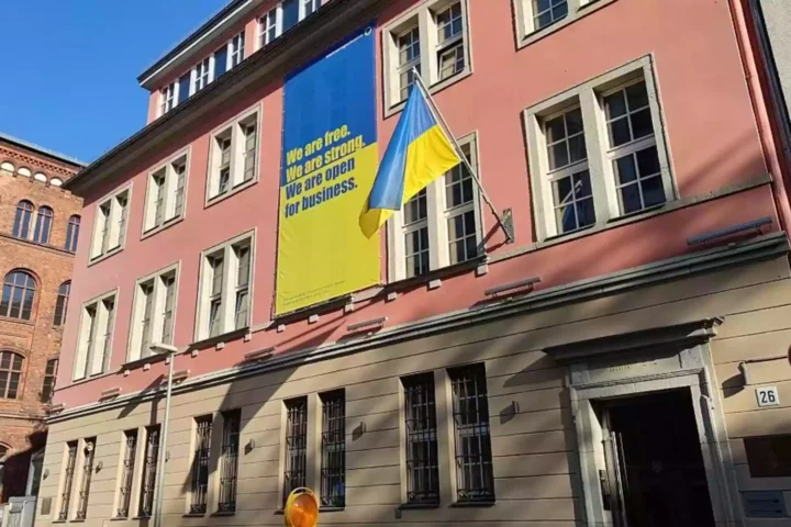 Gebäude mit ukrainischer Flagge und großem Unterstützungsbanner an der Fassade.