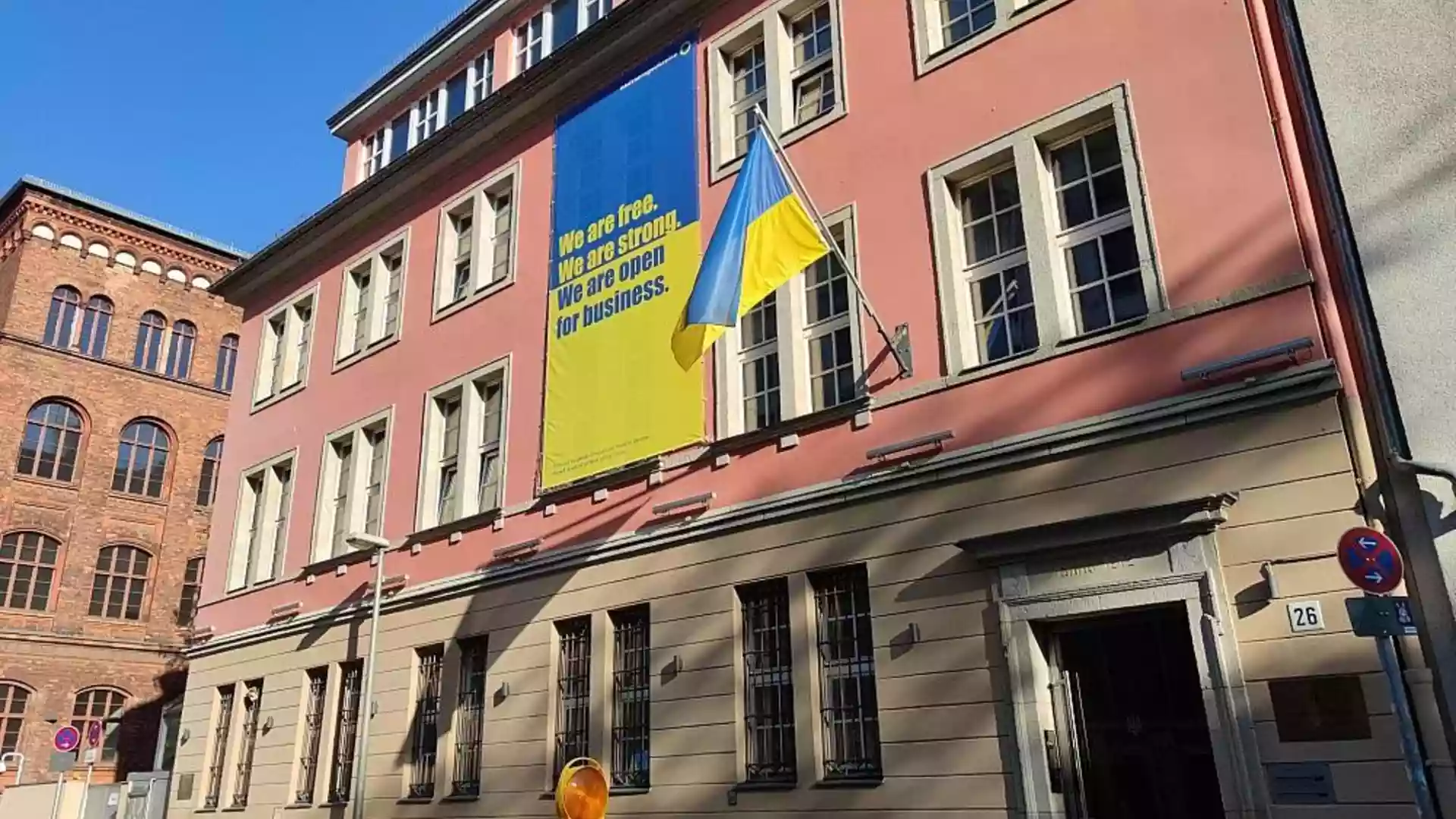 Gebäude mit ukrainischer Flagge und großem Unterstützungsbanner an der Fassade.