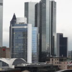 Frankfurter Hochhäuser mit dem Deutsche-Bank-Logo vor bewölktem Himmel.
