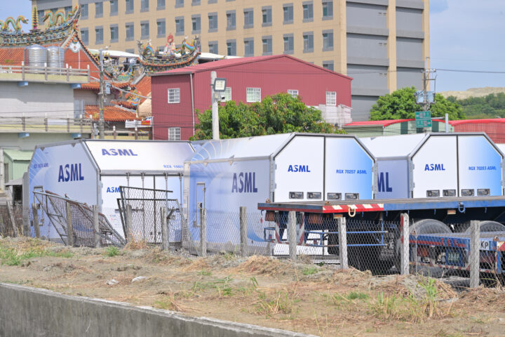ASML-beschriftete Transportcontainer stehen auf einem Gelände vor Gebäuden.