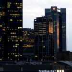 Frankfurter Skyline mit beleuchteten Hochhäusern am Abend.