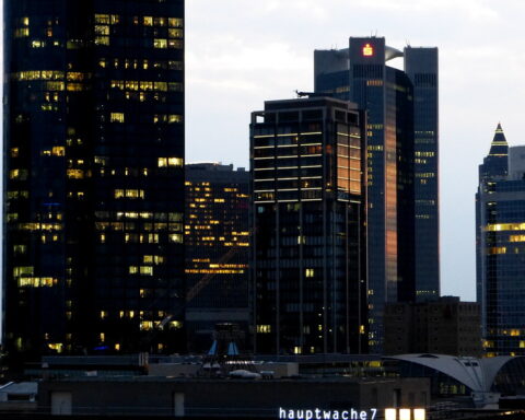 Frankfurter Skyline mit beleuchteten Hochhäusern am Abend.