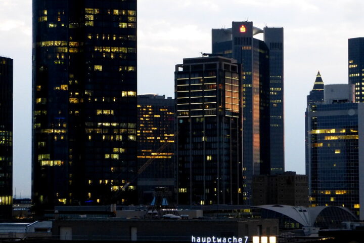Frankfurter Skyline mit beleuchteten Hochhäusern am Abend.